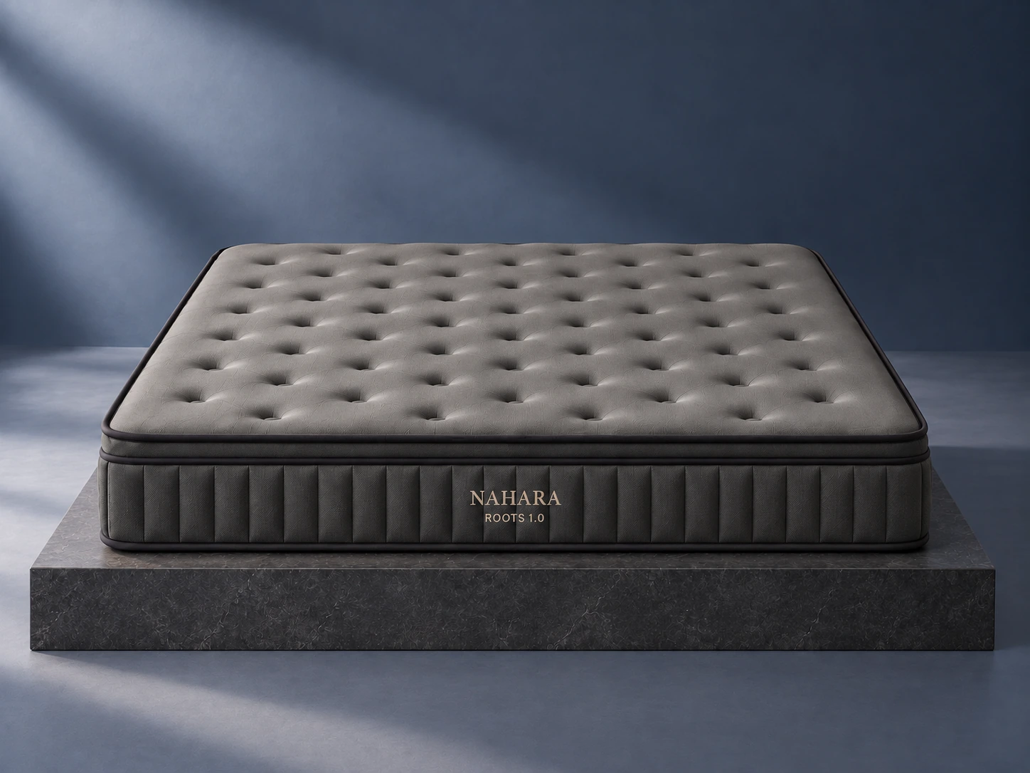 Dark grey ROOTS 1.0 mattress viewed from the front in a blue-grey studio setting