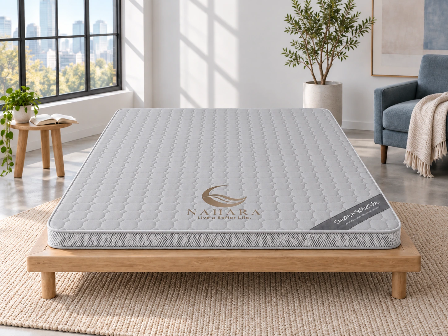Grey NAHARA NEST 1.0 mattress, viewed from the front in a bright studio with a blue reading chair